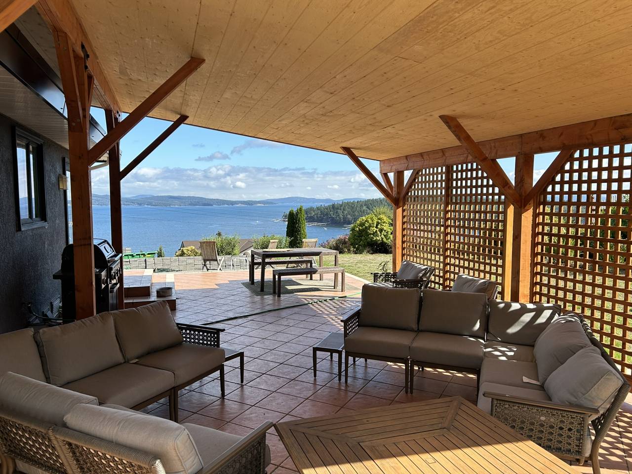 Furnished covered outdoor living space overlooking the water