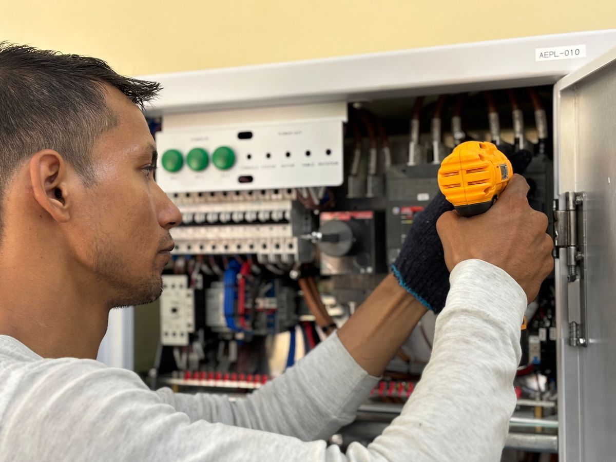 Electrician working at an electrical panel - stock illustration